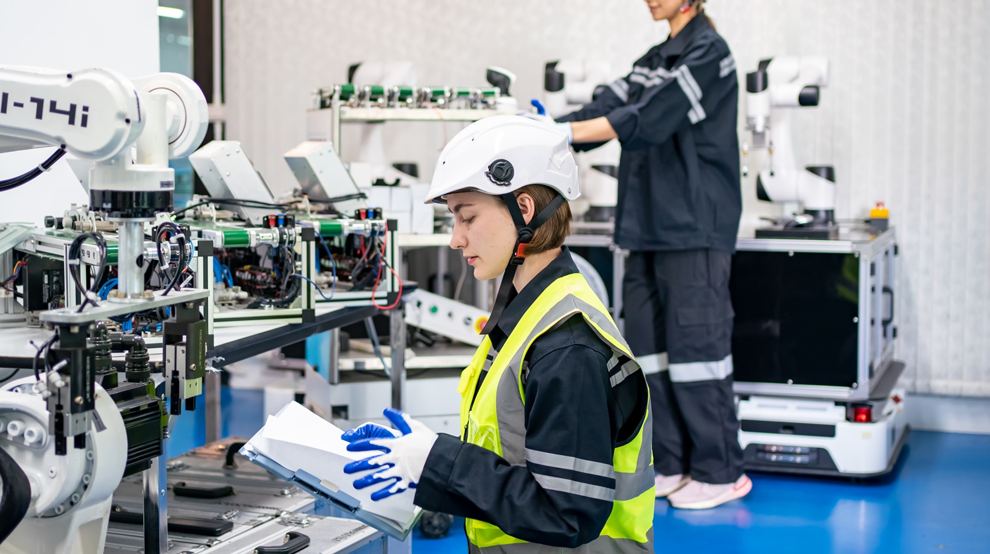 Female Engineer check and control automation robot arms machine in intelligent factory industrial on real time monitoring system software. robotics and digital manufacturing operation.