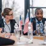 selective focus of attractive businesswoman looking at african american diplomat