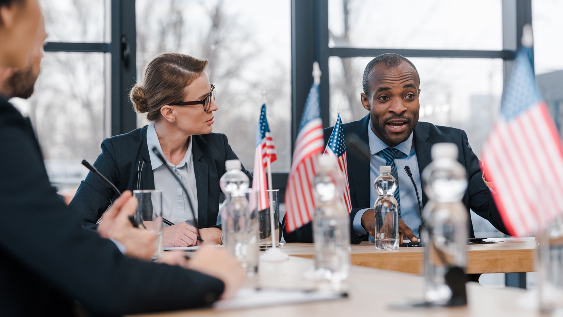 selective focus of attractive businesswoman looking at african american diplomat